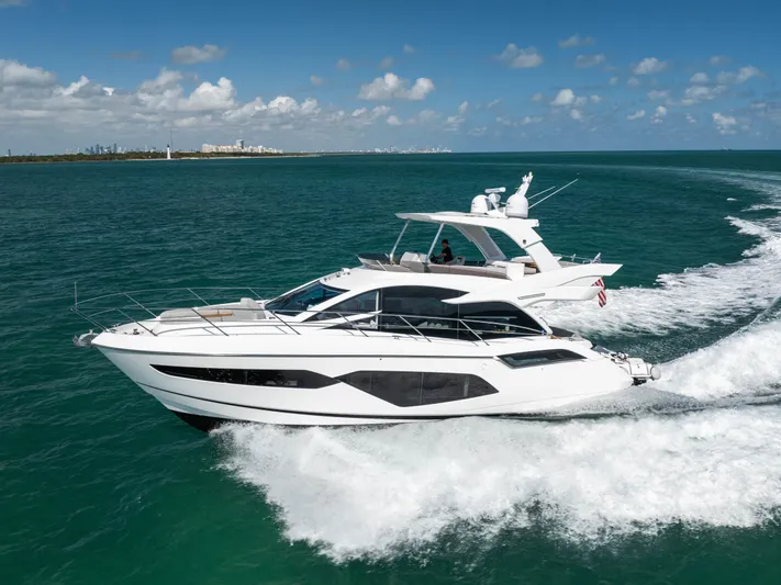 Dreams Yacht Photos Pics 2021 Sunseeker Manhattan 55 yacht cruising on open water under a clear blue sky.