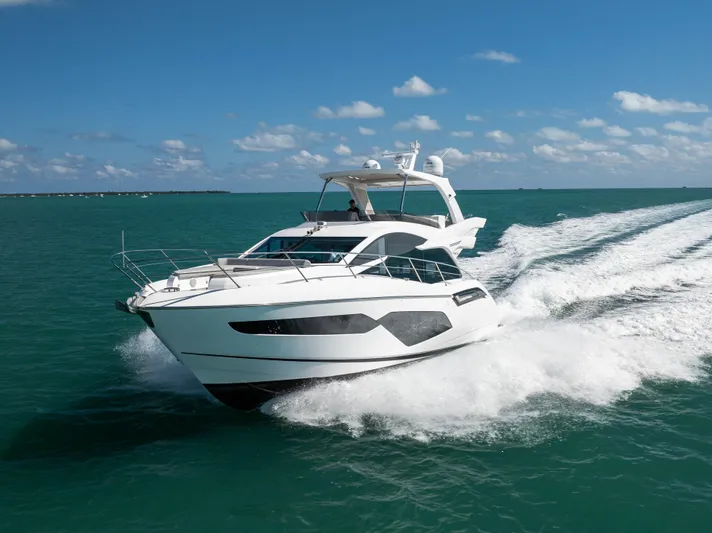 Dreams Yacht Photos Pics 2021 Sunseeker Manhattan 55 yacht cruising on open water under clear skies.