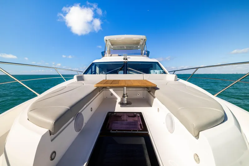 Dreams Yacht Photos Pics 2021 Sunseeker Manhattan 55 yacht deck with seating and table, under clear blue sky.