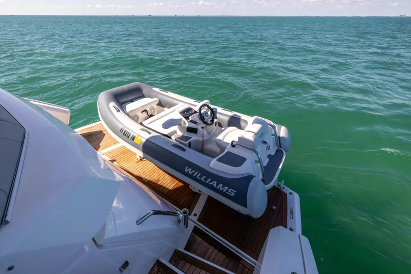 Dreams Yacht Photos Pics 2021 Sunseeker Manhattan 55 yacht with Williams tender on deck, floating on calm sea.