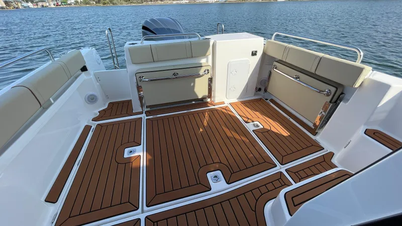  Yacht Photos Pics 2025 Ranger Tugs R-25 boat deck with wood finish, spacious seating, and scenic water view.