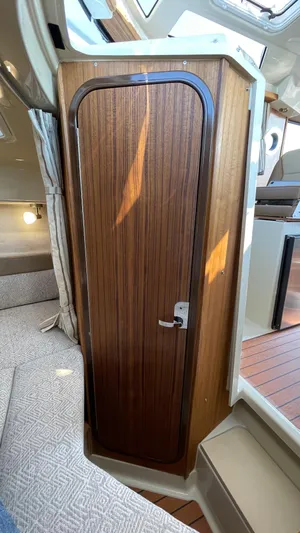  Yacht Photos Pics Interior of 2025 Ranger Tugs R-25, featuring a wooden cabin door and cozy seating area.
