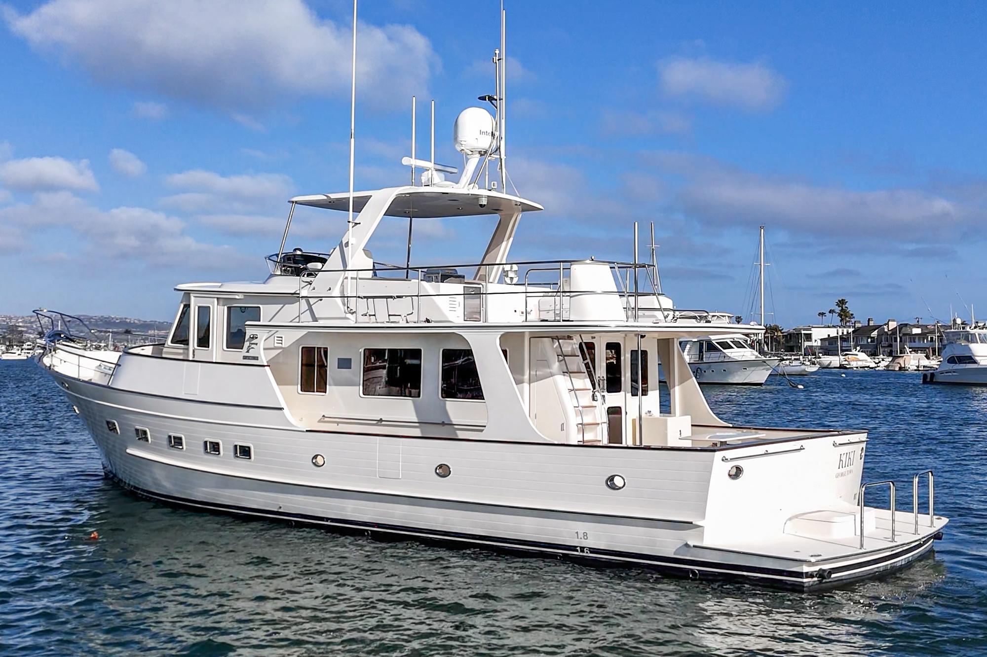 2018 Fleming 58 Pilothouse yacht on calm water under blue sky.