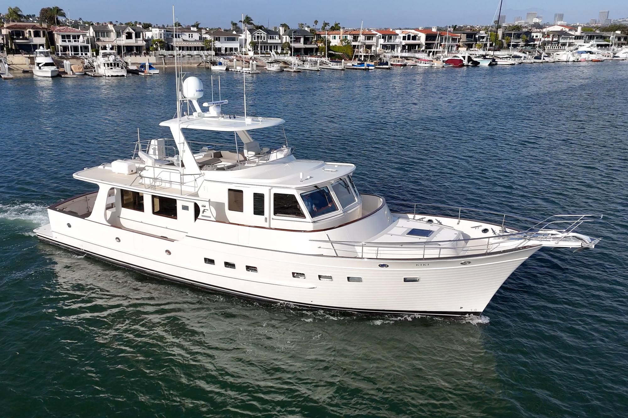 2018 Fleming 58 Pilothouse yacht cruising in a scenic harbor setting.