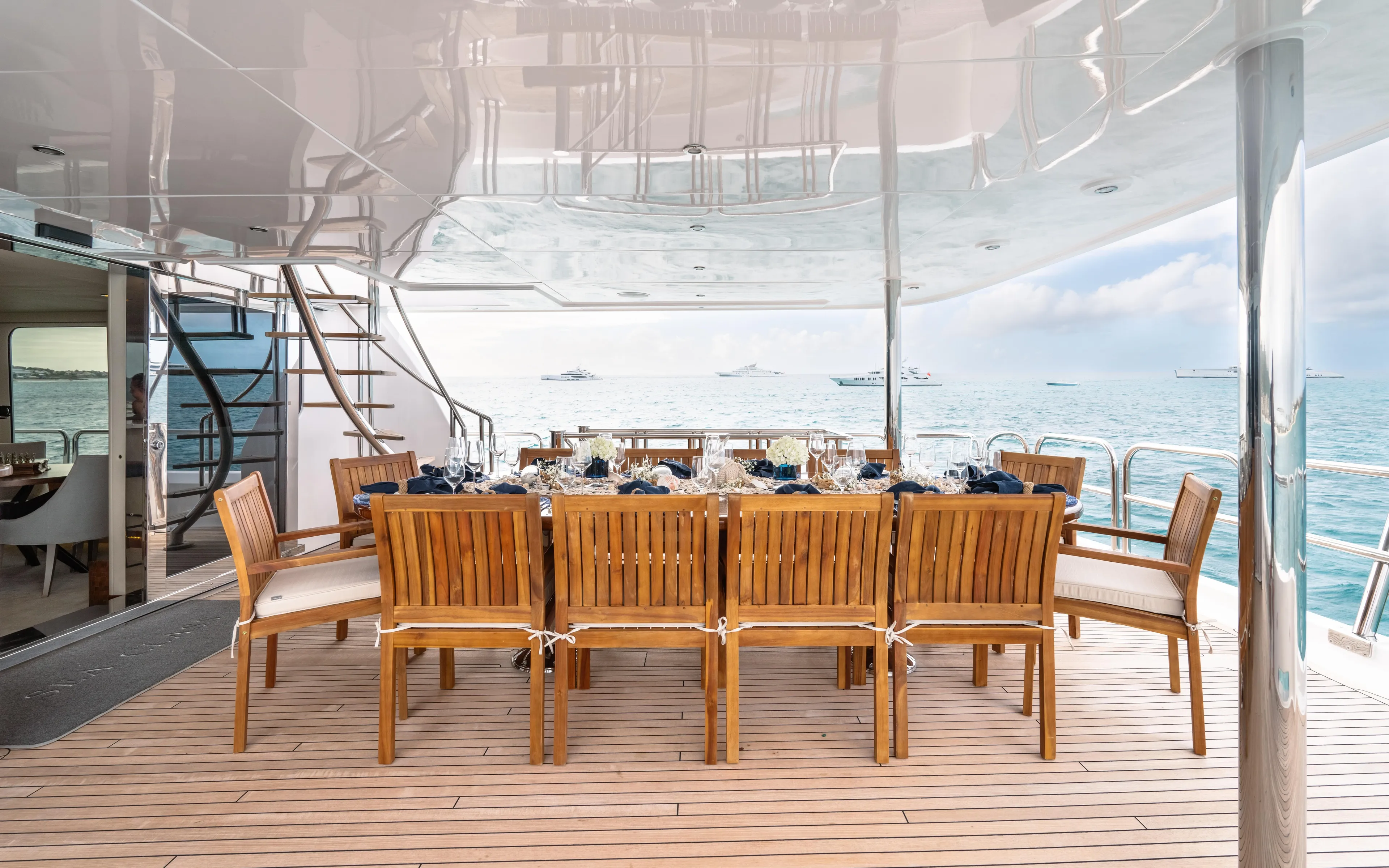 Sea Class Yacht Photos Pics Luxurious dining area on 1997 Christensen yacht with ocean view and elegant wooden furniture.