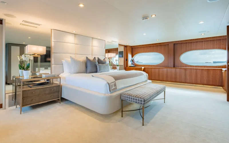 Sea Class Yacht Photos Pics Luxurious yacht bedroom with elegant decor, large bed, and ocean-view windows, Christensen 1997 model.