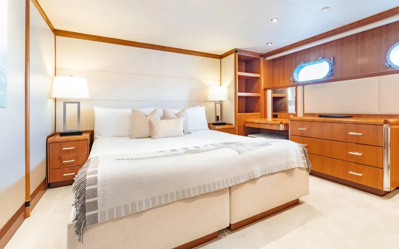 Sea Class Yacht Photos Pics Luxurious yacht bedroom with elegant wood furnishings, soft lighting, and a cozy bed, Christensen 1997 model.