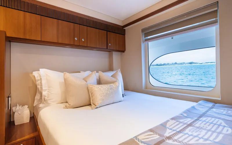 Sea Class Yacht Photos Pics Luxurious yacht bedroom with ocean view, featuring elegant bedding and wooden cabinetry, Christensen 1997 model.