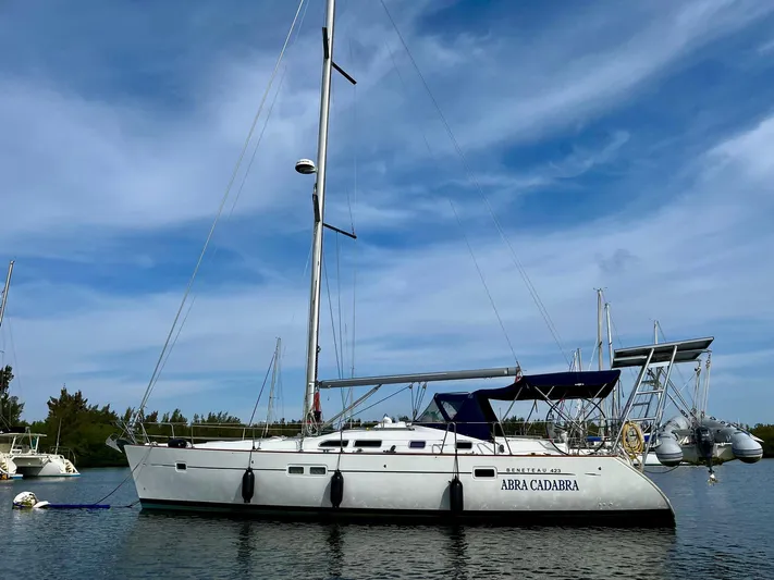 Abra Cadabra Yacht Photos Pics 2004 Beneteau Oceanis 423 sailboat anchored on calm water under a clear blue sky.