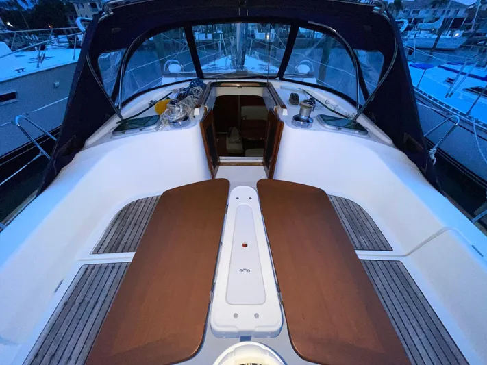 Abra Cadabra Yacht Photos Pics Cockpit of 2004 Beneteau Oceanis 423 sailboat with wooden seating and covered helm.