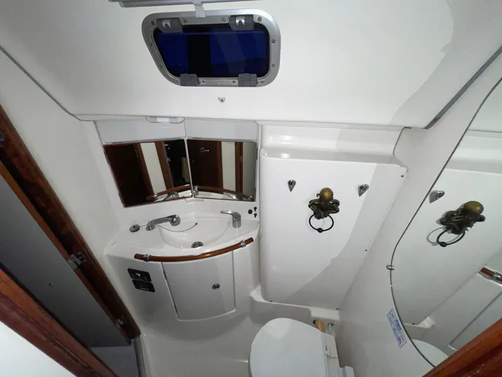 Abra Cadabra Yacht Photos Pics Bathroom interior of 2004 Beneteau Oceanis 423 yacht, featuring sink, mirror, and porthole.