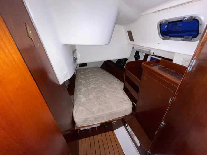 Abra Cadabra Yacht Photos Pics Cabin interior of 2004 Beneteau Oceanis 423 sailboat with bed and wooden storage.