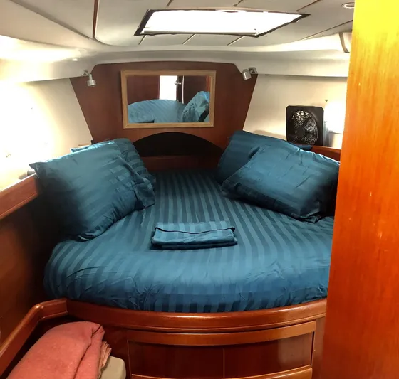 Abra Cadabra Yacht Photos Pics Cozy cabin interior of 2004 Beneteau Oceanis 423 with blue bedding and wooden finish.