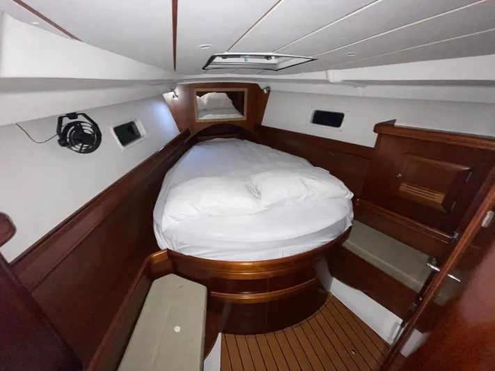 Abra Cadabra Yacht Photos Pics Cozy cabin interior of 2004 Beneteau Oceanis 423 sailboat with wooden finishes and comfortable bedding.