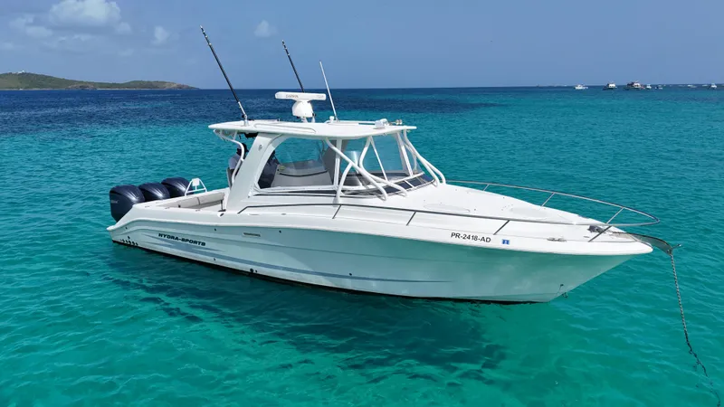  Yacht Photos Pics 2009 Hydra-Sports 3500 VX boat on clear turquoise water, anchored near a distant island.