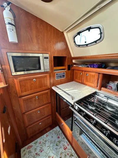 "orion" Yacht Photos Pics 2012 Hunter 45 Deck Salon kitchen with wood cabinetry, microwave, and stove.