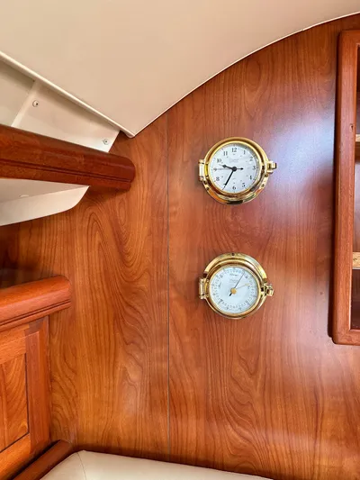 "orion" Yacht Photos Pics Interior of 2012 Hunter 45 Deck Salon with wooden paneling and brass instruments.