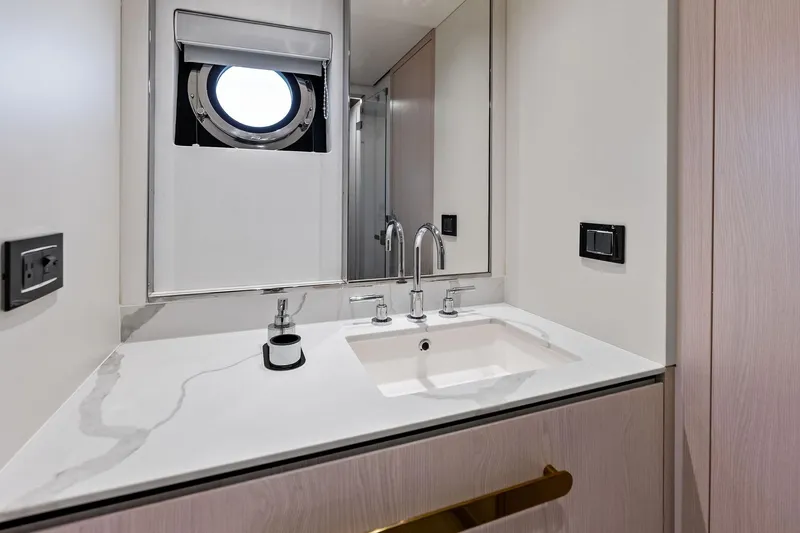  Yacht Photos Pics Luxurious bathroom interior of 2021 Azimut Fly 78 yacht with modern sink and porthole window.