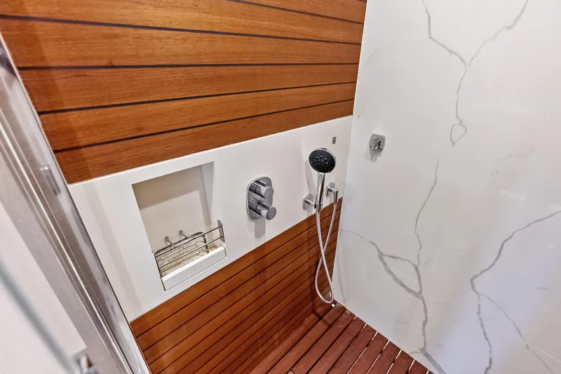  Yacht Photos Pics Luxurious shower in 2021 Azimut Fly 78 yacht with wood paneling and modern fixtures.