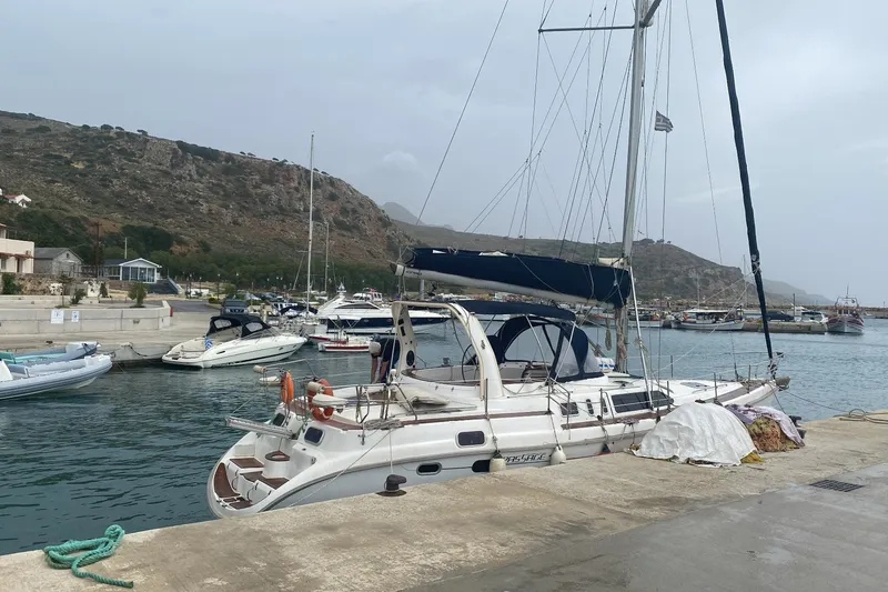  Yacht Photos Pics Sailboat docked in marina, 2000 Hunter 45 Center Cockpit, with scenic hillside backdrop.