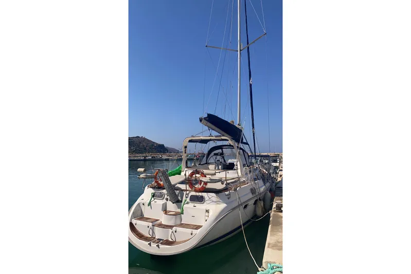  Yacht Photos Pics Hunter 45 Center Cockpit sailboat, 2000 model, docked at a marina under clear blue skies.