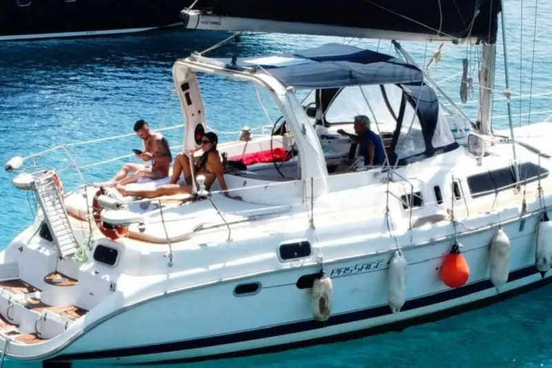  Yacht Photos Pics People relaxing on a 2000 Hunter 45 Center Cockpit sailboat in clear blue water.
