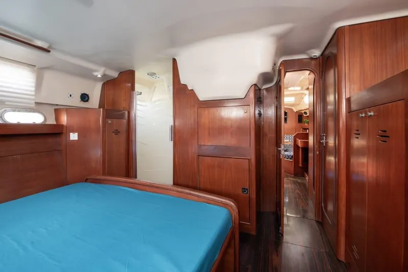  Yacht Photos Pics Interior of 2000 Hunter 45 Center Cockpit yacht with wooden furnishings and blue bedding.