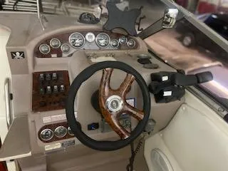 Steering console of a 2003 Regal 2765 boat with wood accents and gauges.