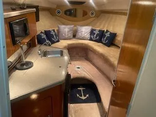 Interior of a 2003 Regal 2765 boat with anchor-themed decor and compact kitchenette.