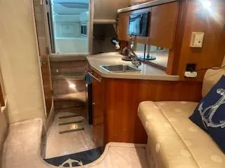 Interior of a 2003 Regal 2765 boat, featuring a compact kitchen and seating area.