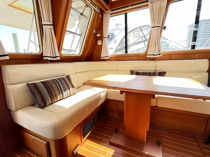 Mon Alisa Yacht Photos Pics Interior of 2004 Sabre 36 Sedan with cozy seating and wooden table.