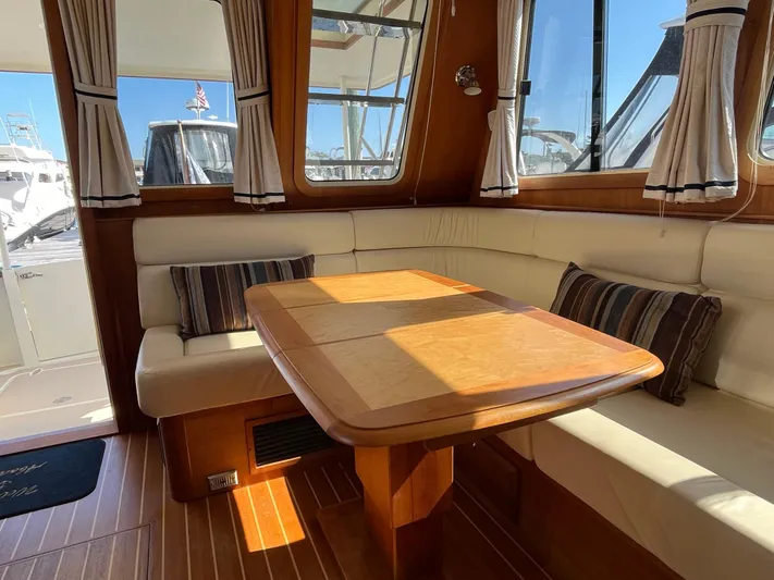 Mon Alisa Yacht Photos Pics Interior of 2004 Sabre 36 Sedan with wooden table and cushioned seating.