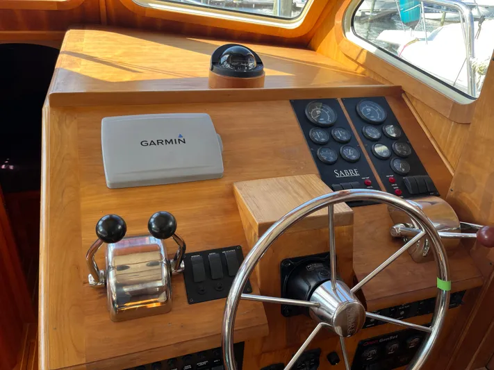 Mon Alisa Yacht Photos Pics 2004 Sabre 36 Sedan helm with Garmin navigation and classic wooden steering wheel.