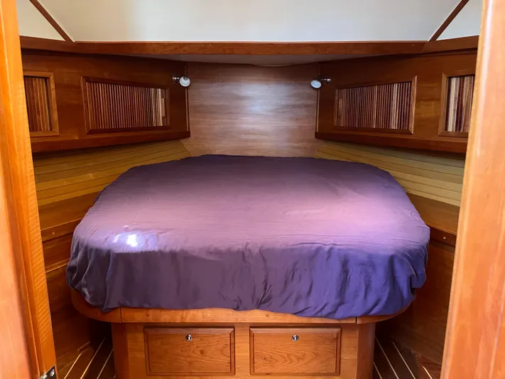 Mon Alisa Yacht Photos Pics Cozy cabin interior of 2004 Sabre 36 Sedan with wooden finish and purple bedding.