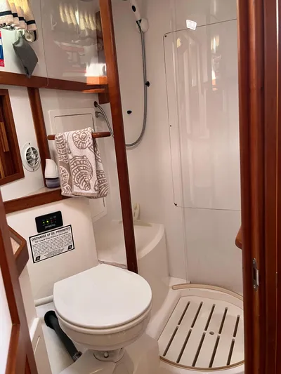 Mon Alisa Yacht Photos Pics 2004 Sabre 36 Sedan bathroom with shower, toilet, and wooden accents.