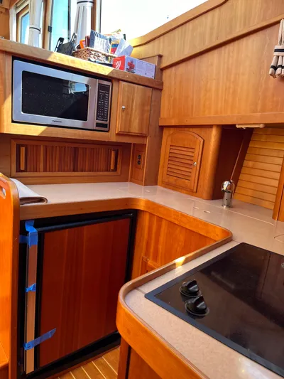 Mon Alisa Yacht Photos Pics 2004 Sabre 36 Sedan yacht kitchen with microwave, stove, and wooden cabinetry.
