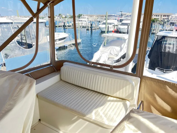 Mon Alisa Yacht Photos Pics 2004 Sabre 36 Sedan interior with marina view, featuring a white cushioned seat.