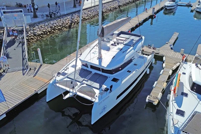 Just Wonder Yacht Photos Pics 2024 Cervetti 44 catamaran docked at a marina, viewed from above.