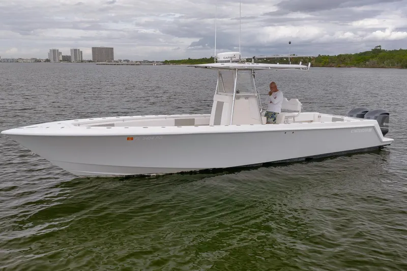 Yacht Photos Pics 2012 Contender 32 Tournament boat on calm water with a person onboard.