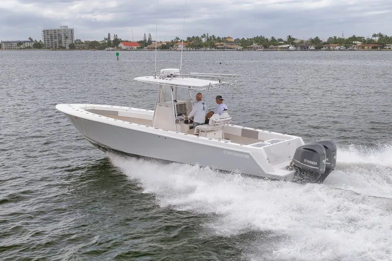  Yacht Photos Pics 2012 Contender 32 Tournament boat cruising on water with two people onboard.