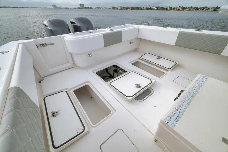  Yacht Photos Pics 2012 Contender 32 Tournament boat deck with storage compartments, ocean view in background.