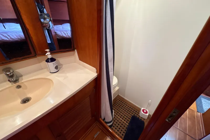 Ganymede Yacht Photos Pics 2001 North Wind 56 yacht bathroom with sink, mirror, and shower area.