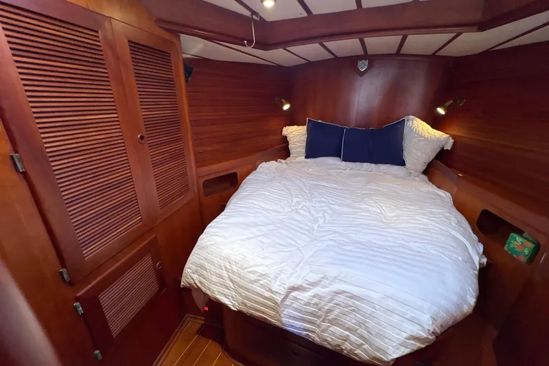 Ganymede Yacht Photos Pics Cozy cabin bedroom in 2001 North Wind 56 yacht with wooden interior and comfortable bedding.