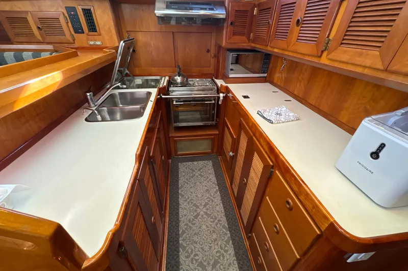 Ganymede Yacht Photos Pics Luxurious wooden yacht kitchen interior, North Wind 56, 2001 model, featuring modern appliances.