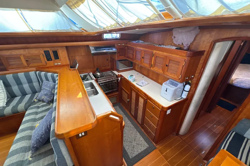 Ganymede Yacht Photos Pics Luxurious 2001 North Wind 56 yacht interior with wood cabinetry and cozy seating area.