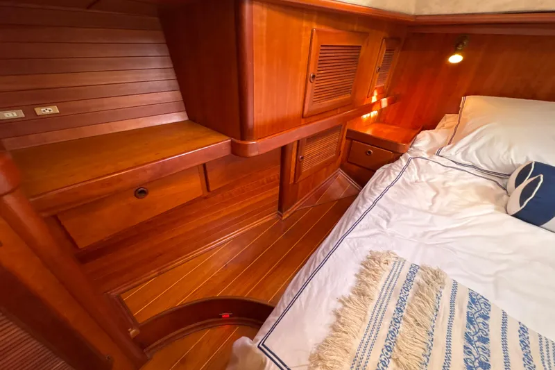 Ganymede Yacht Photos Pics Luxurious wooden cabin interior of a 2001 North Wind 56 yacht, featuring cozy bedding.