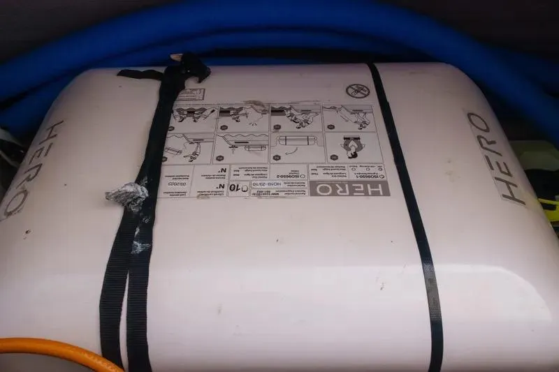  Yacht Photos Pics Life raft labeled "HERO" secured with straps, featuring instructional diagrams.