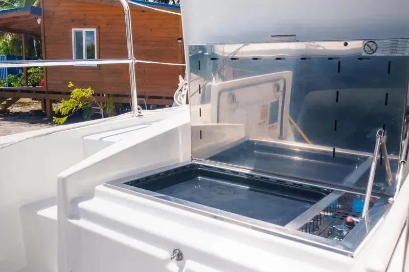  Yacht Photos Pics Outdoor kitchen on 2023 Bali 4.4 yacht with stainless steel grill and wooden cabin backdrop.