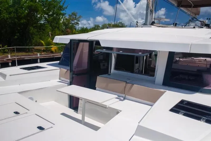  Yacht Photos Pics 2023 Bali 4.4 yacht with spacious deck and seating area under clear blue sky.