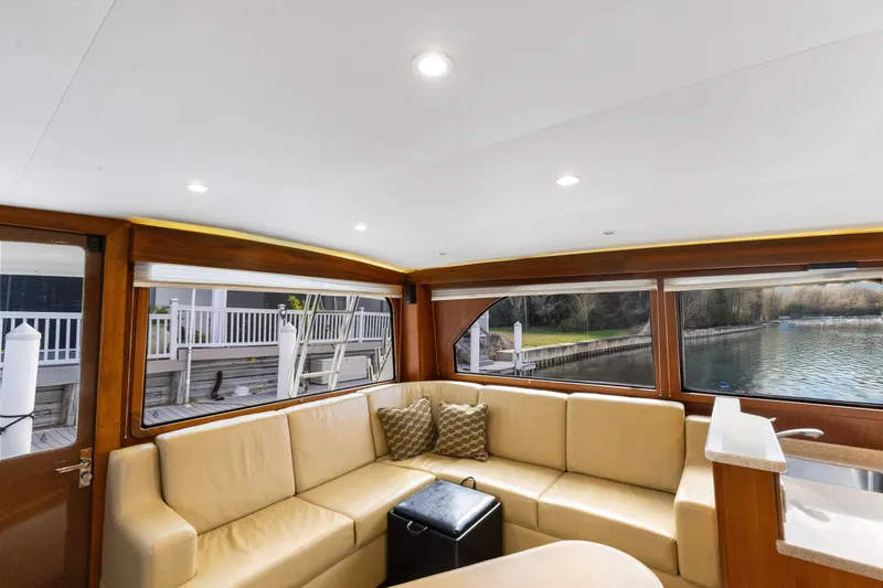 Well Played Yacht Photos Pics Luxurious interior of 2011 Cabo 40 Flybridge yacht with beige seating and waterfront view.